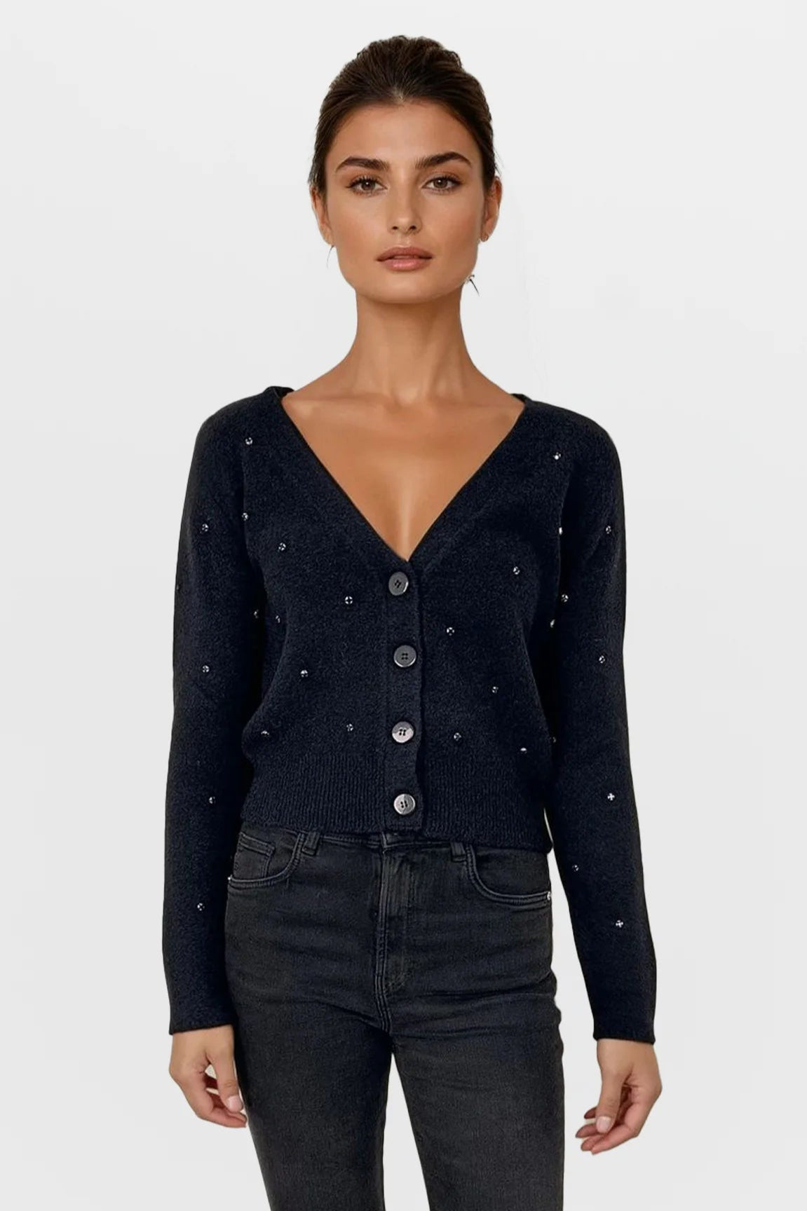 Woman wearing a black cardigan with button details on a white background
