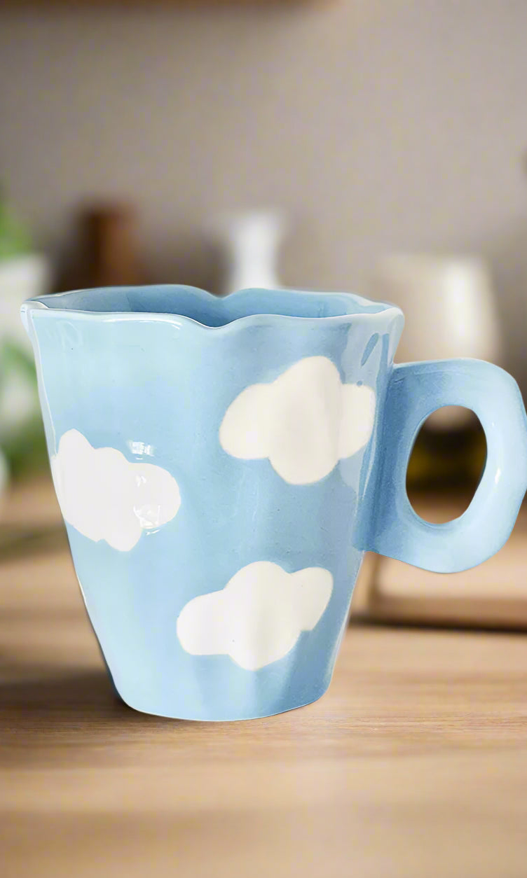 Blue mug with cloud designs on a white background