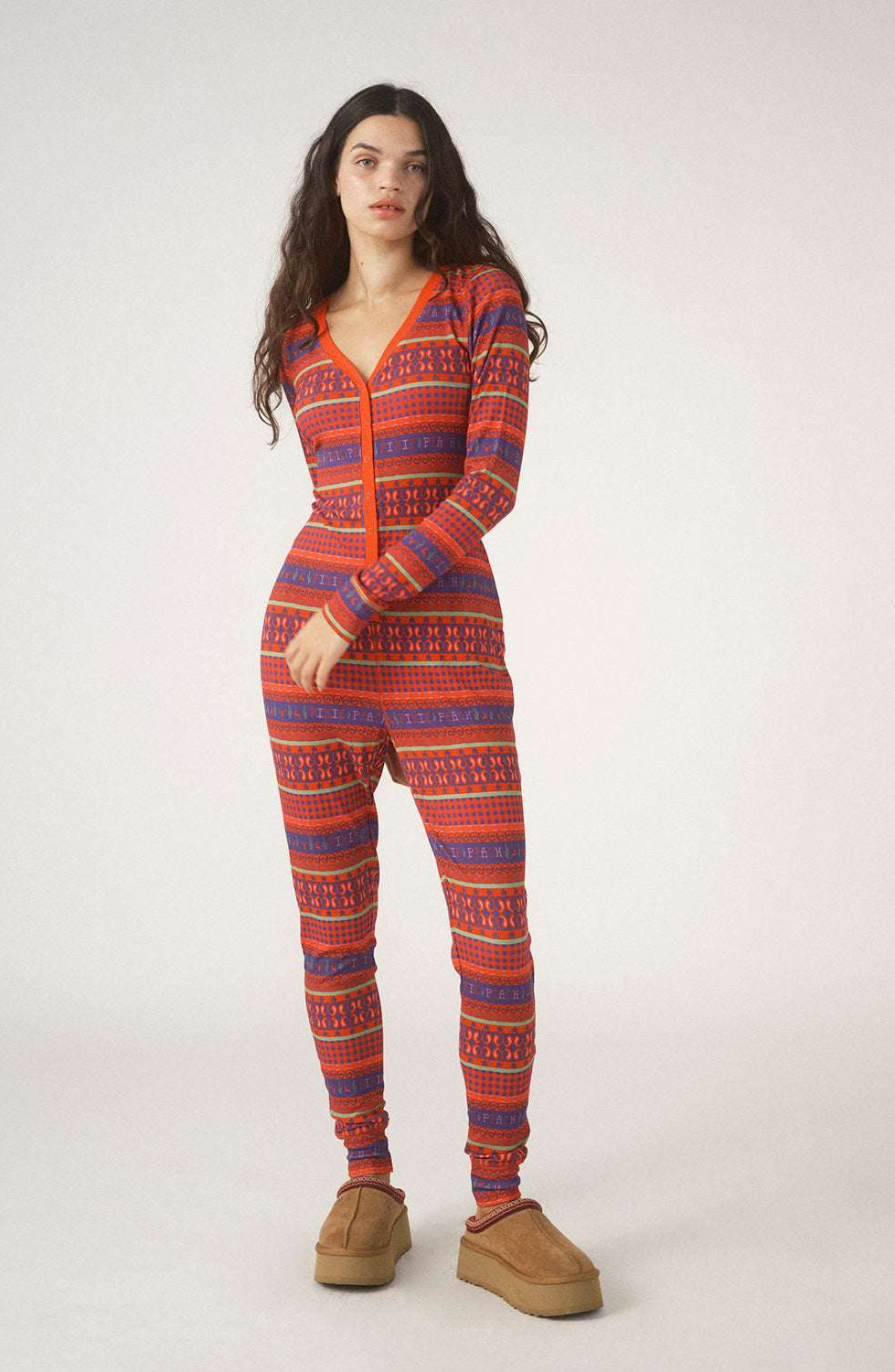 Person wearing a red and blue patterned onesie on a white background