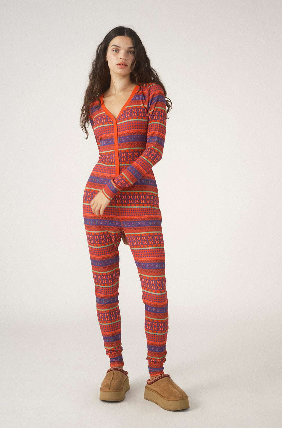 Person wearing a red and blue patterned onesie on a white background