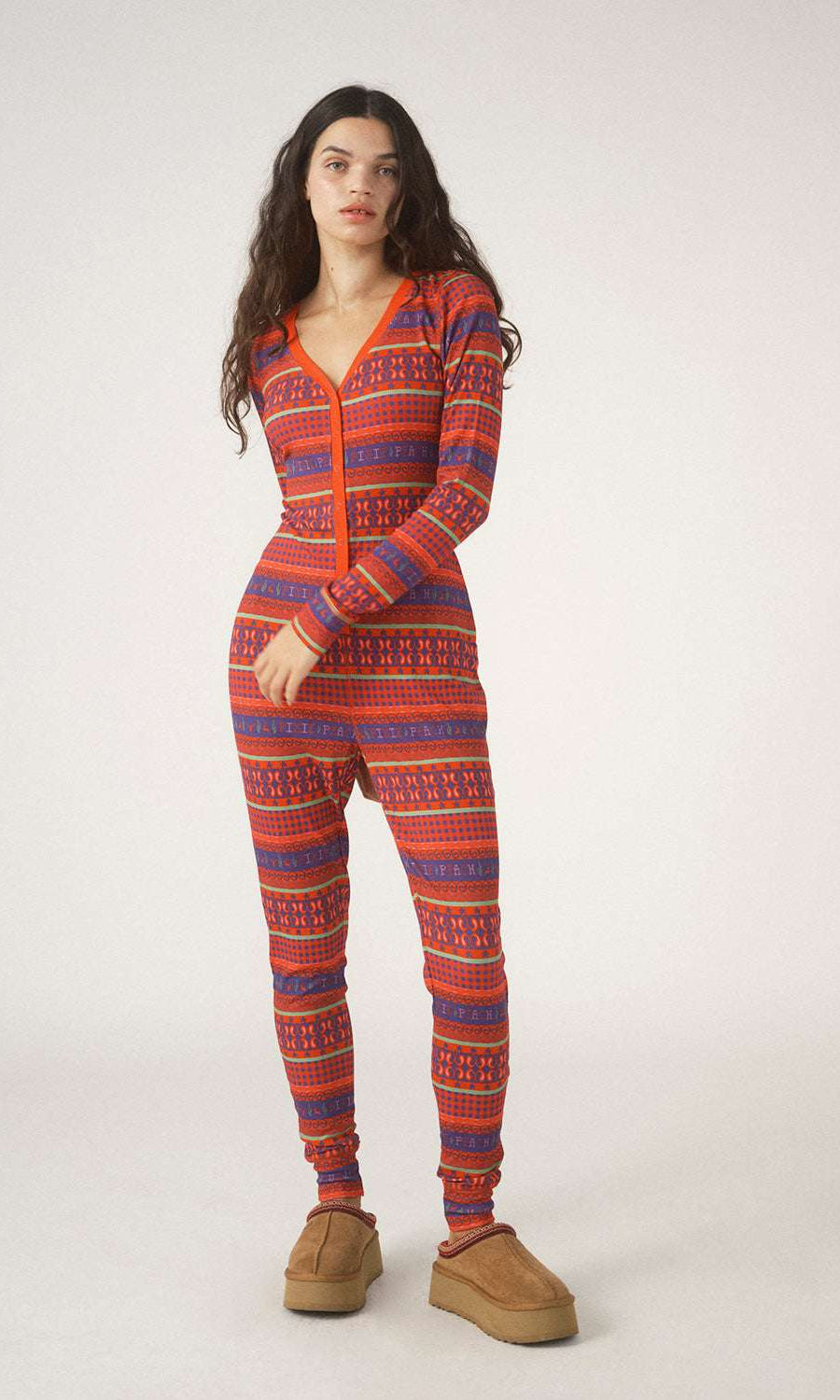 Person wearing a red and blue patterned onesie on a white background