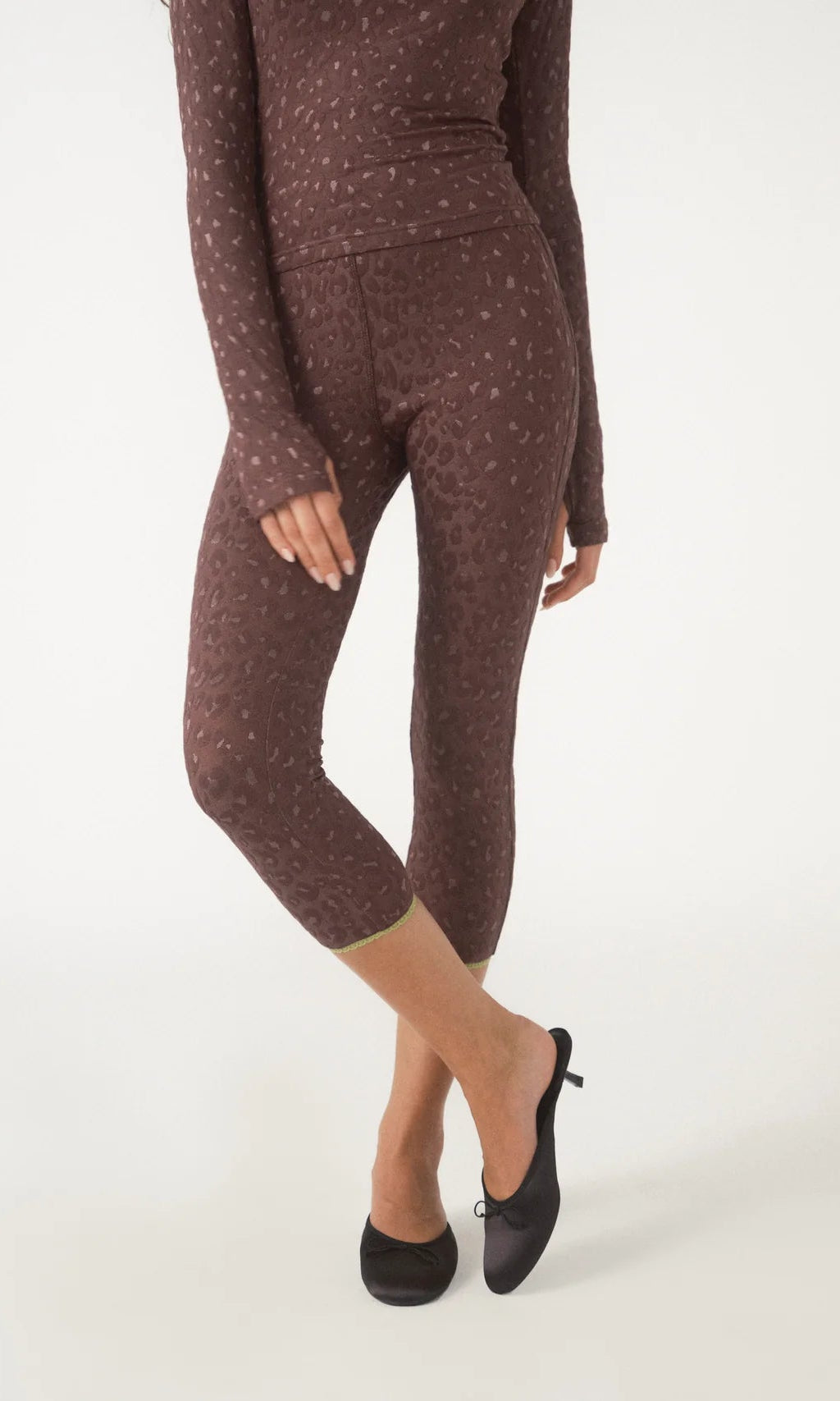 Brown polka dot leggings worn by a person on a white background