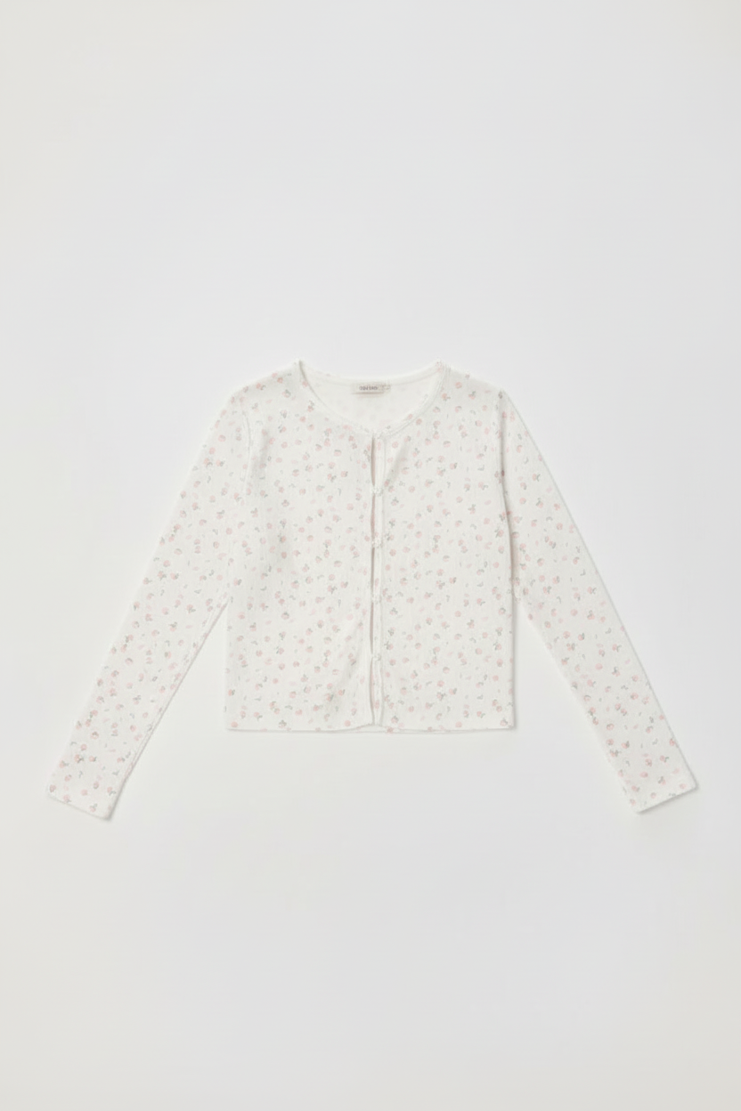 White long-sleeve top with subtle pattern on a light gray background