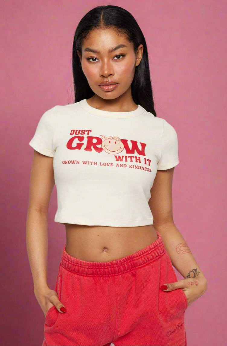 Samii Ryan x Smileyworld® Just Grow With It Baby Tee T-Shirt by Samii Ryan as seen on celebrities