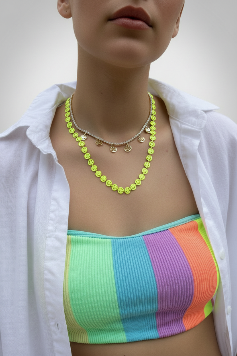 Person wearing a colorful striped top and white shirt with a necklace.