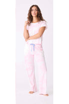 Woman wearing a pink pajama set with a white background