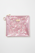 Pink glittery pouch with a gold zipper on a light gray background