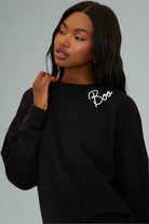 Person wearing a black sweatshirt with 'Boo' text on a white background